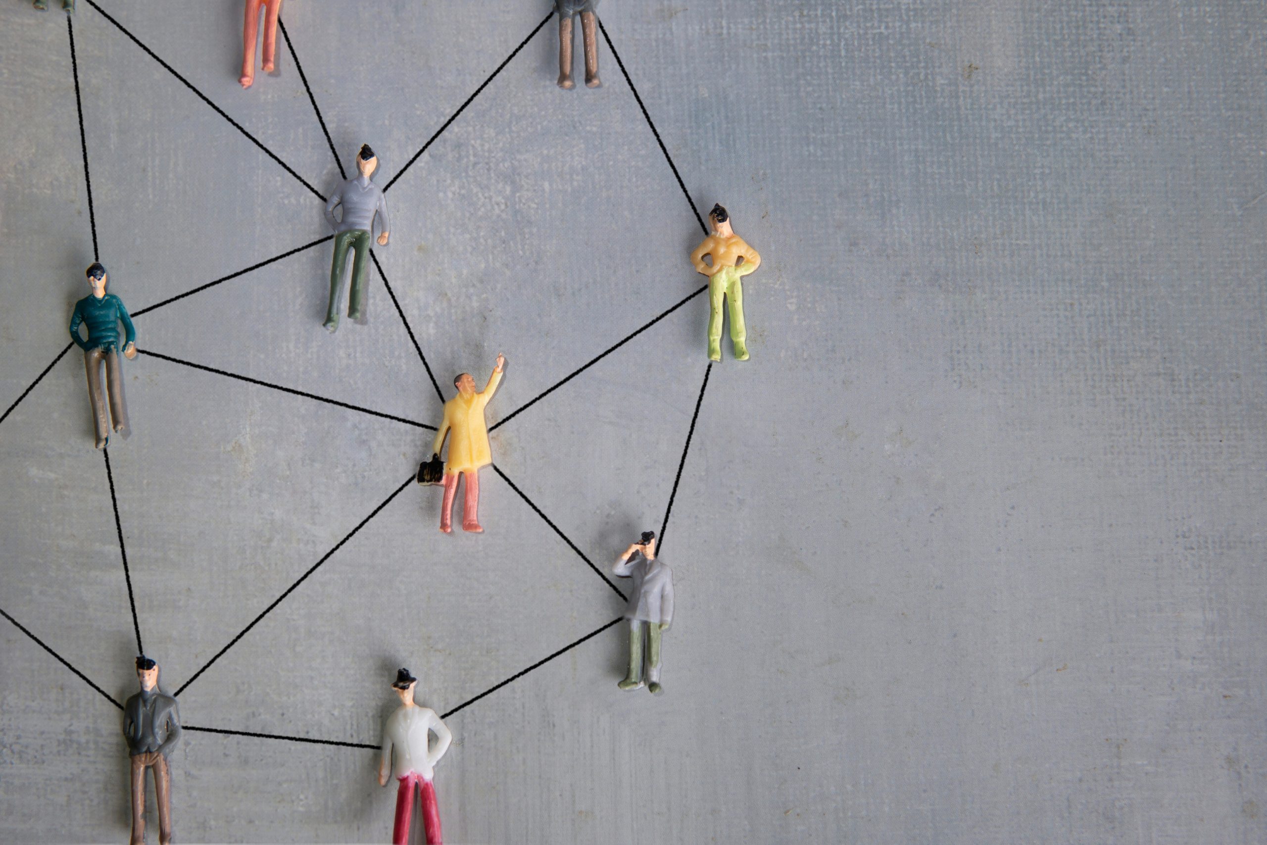 Miniature people connected with arrows. Networking concept. Copy space for text.